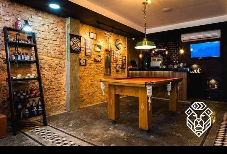 Fotografia da área de convivência, com mesa de sinuca e balcão de bar.