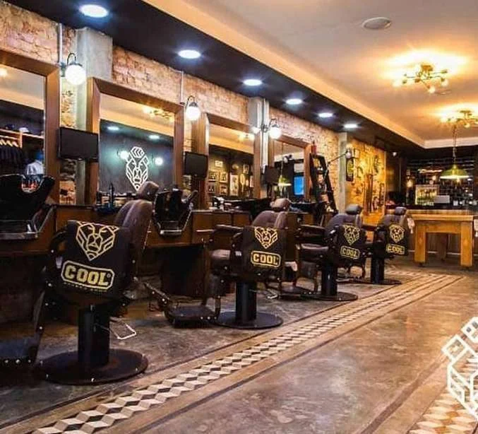 Fotografia do interior da Cool Barber Shop, com tijolos aparentes, mobiliário escuro e iluminação quente.